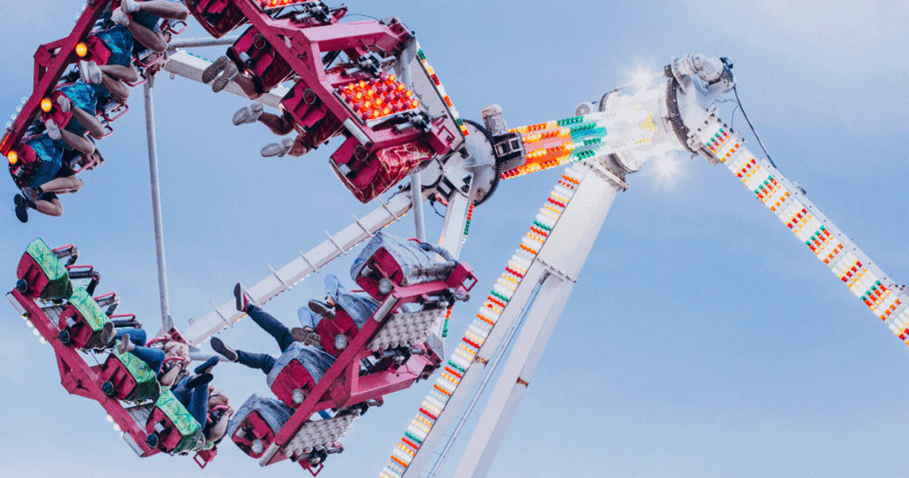 A group of people on a square shaped ride that swings back and forth like a pendulum.