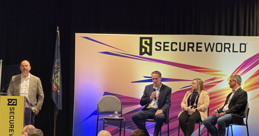 Four cybersecurity industry professionals participate in a panel discussion during a SecureWorld conference event.
